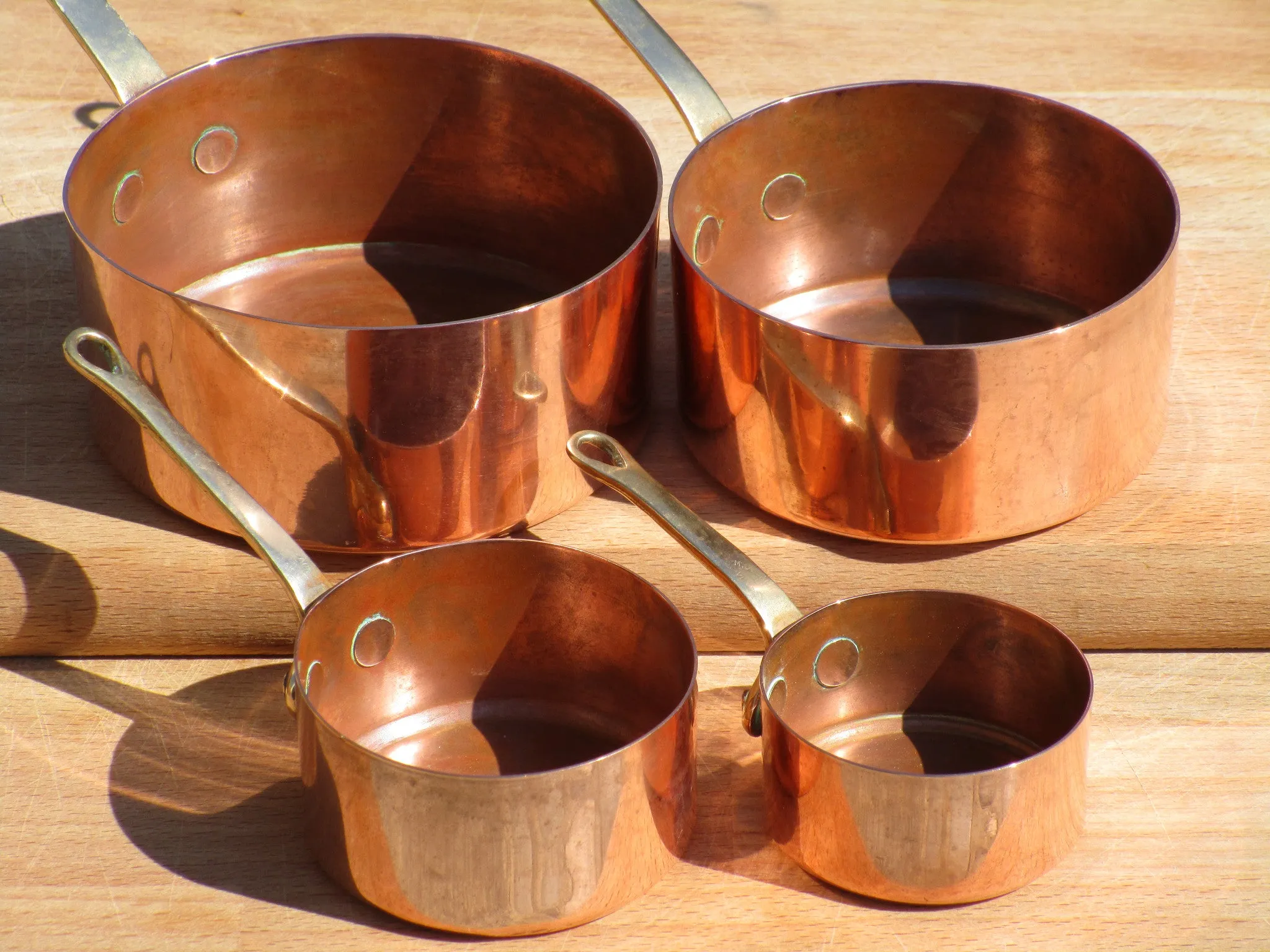 Set of four chef's copper saucepans