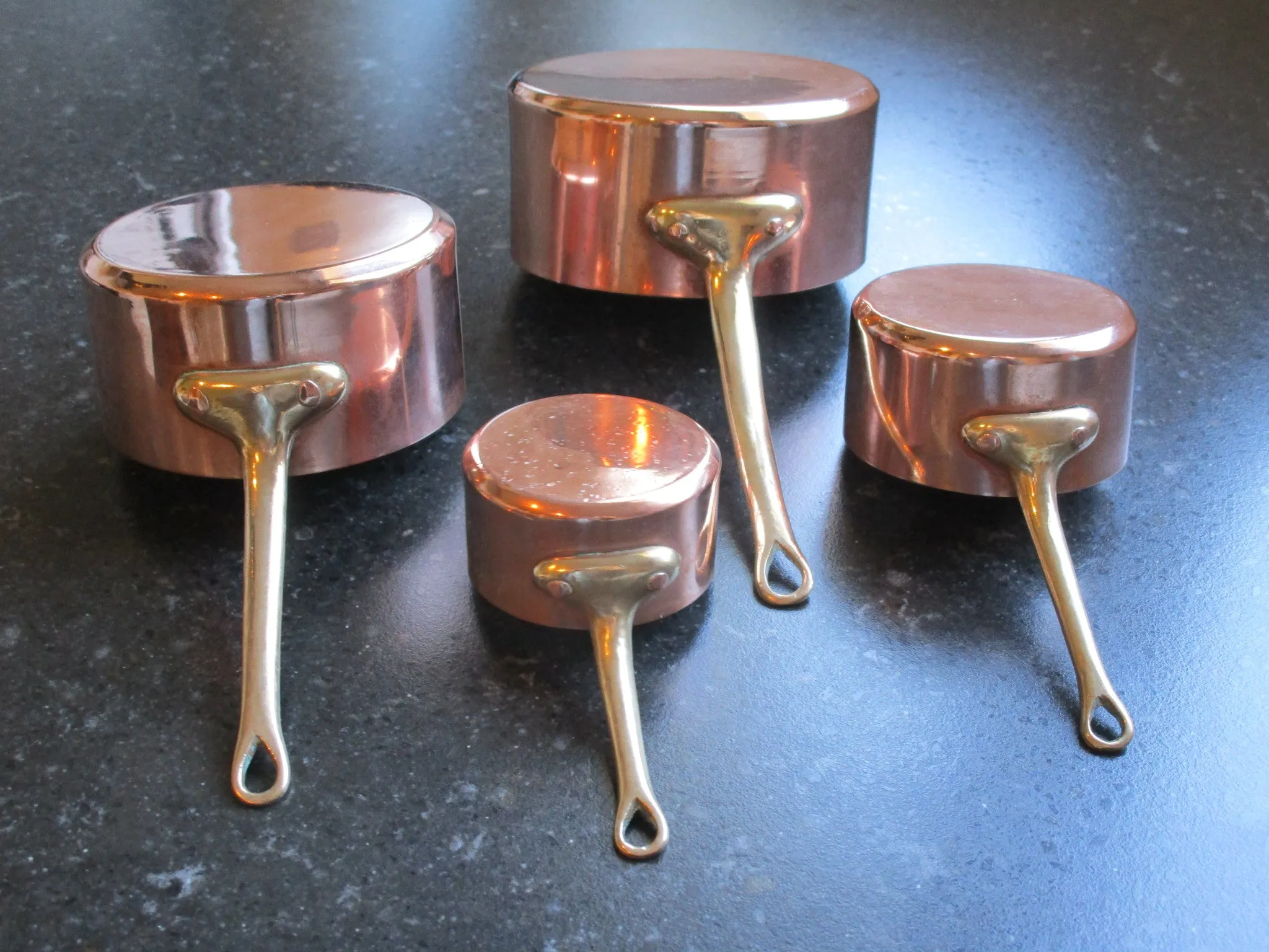 Set of four chef's copper saucepans